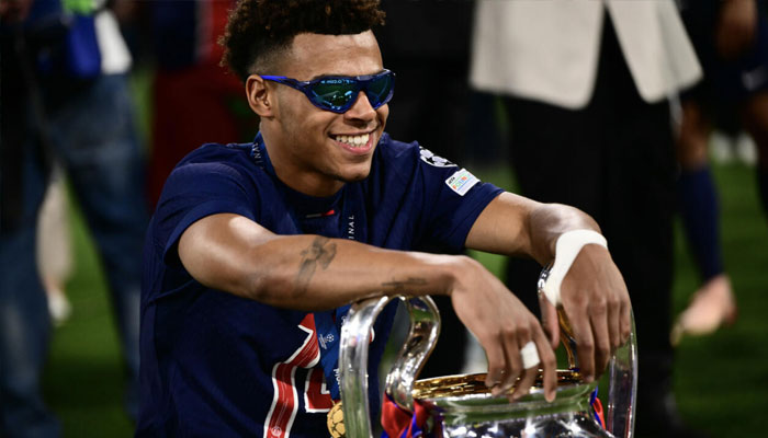 Desire Doue poses with the trophy after starring in Paris Saint-Germains remarkable Champions League final win over Inter Milan on Saturday . —AFP