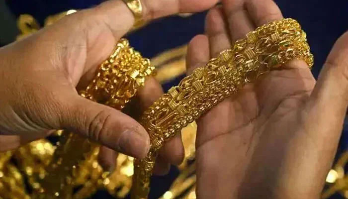 This representational image shows a person holding gold necklaces. — AFP/File