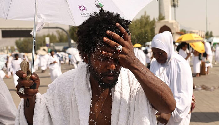 A Muslim pilgrim splashes water on his head to cool off at the base of Saudi Arabias Mount Arafat, also known as Jabal al-Rahma, during the climax of the Hajj pilgrimage on June 15, 2024. — AFP