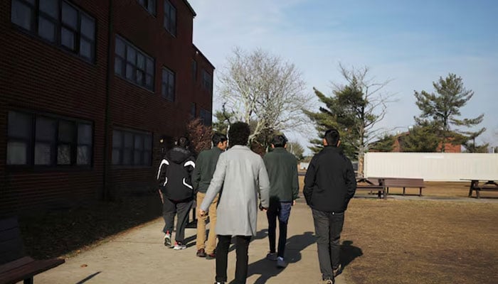 A group of Afghan youth walk outside their temporary housing in Liberty Village on Joint Base McGuire-Dix-Lakehurst in New Jersey, US, December 2, 2021. —Reuters