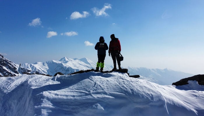 In this image, people are standing at the peak of a mountain. — capturepakistan/File