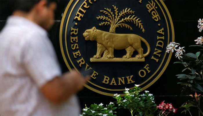 A man checks his phone outside the Reserve Bank of India (RBI) headquarters in Mumbai, India, April 5, 2018. — Reuters