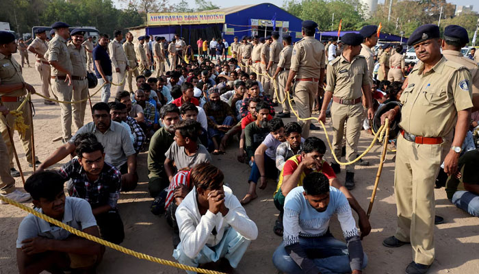 Police officers stand next to men they believe to be undocumented Bangladeshi nationals after they were detained during raids in Ahmedabad, India, April 26, 2025. —Reuters