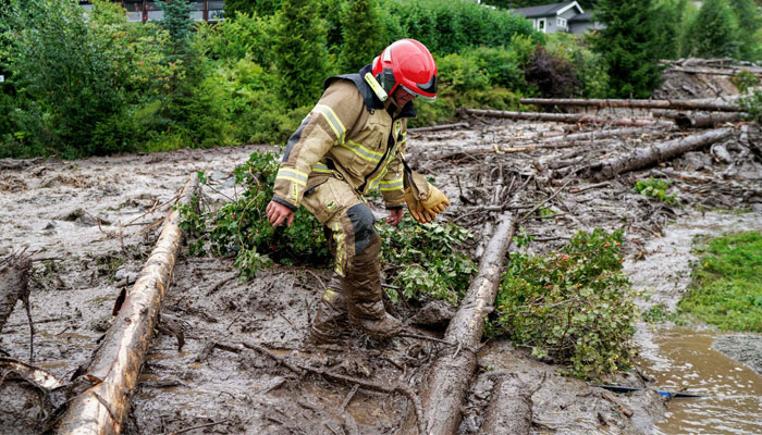A representational image of a firefighter wades through mud following a storm. — AFP/File