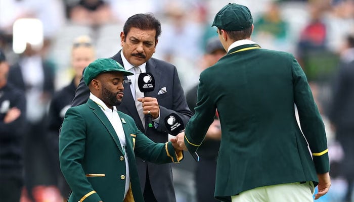 Australias Pat Cummins with South Africas Temba Bavuma during the coin toss as former India cricketer and commentator Ravi Shastri looks on, June 11, 2025. —Reuters