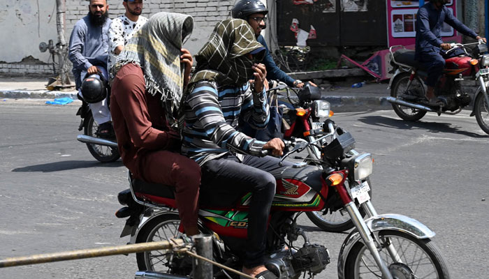 A motorcyclist covers his face with a scarf to shield against the soaring summer temperatures in the Provincial Capital on June 11, 2025. — APP
