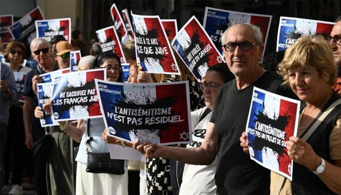 Demonstrators hold placards denouncing an increase in anti-Semitic attacks in France at a protest in Lyon on June 19, 2024.—AFP