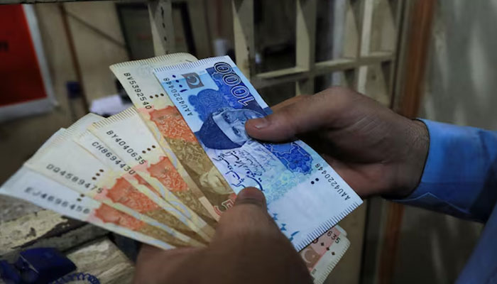 A man counts Pakistani rupee notes at a currency exchange shop in Peshawar, Pakistan September 12, 2023.—Reuters