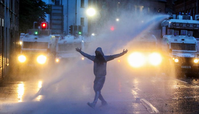 Police firing with water guns on a person. —AFP/File