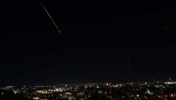 This picture shows a rocket trail from Israels Iron Dome missile defense system batteries fired to intercept rockets launched from Iran above the Dome of the Rock in the al-Aqsa mosque compound in Jerusalems Old City on June 13, 2025. — AFP