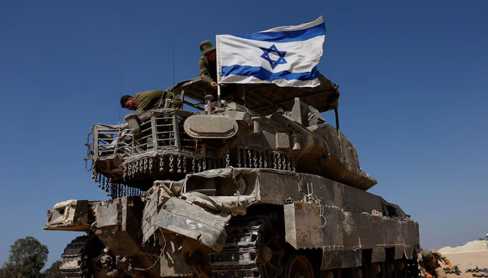 Israeli soldiers mount an Israeli flag on a military vehicle. — Reuters/File