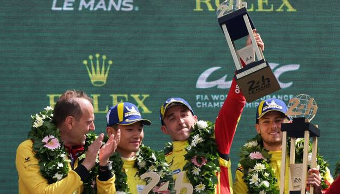 AF Corse’s Robert Kubica, Yifei Ye and Philip Hanson celebrate with their medals and trophy on the podium after winning the 24 Hours of Le Mans along with team principal Amato Ferrari on Sunday. —Reuters