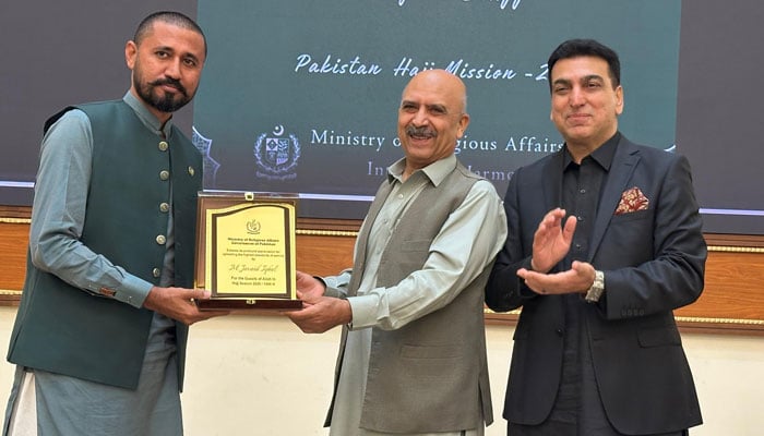 Federal Secretary for the Ministry of Religious Affairs, Dr Syed Ataur Rehman (centre) presents a shield to a staff member on June 16, 2025. — Facebook@mora.official