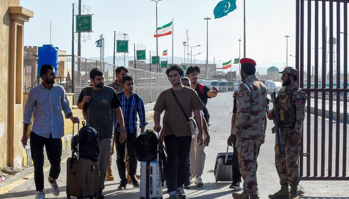 Pakistani students evacuated from Iran walk across the Pakistan-Iran border at Taftan, in Balochistan province on June 18, 2025. — AFP