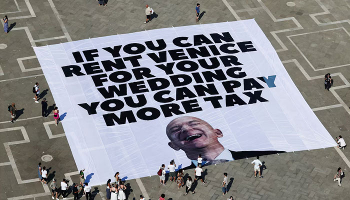 A large banner against Amazon founder Jeff Bezos lies on the ground, placed by Greenpeace Italy activists along with others in St Marks Square, ahead of the expected wedding of Amazon founder Jeff Bezos and Lauren Sanchez, in Venice, Italy, June 23, 2025.—Reuters