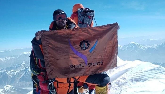 Ashraf Sadpara holds flag of SNGPL sports. &mdash; Reporter/File