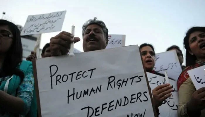 Protesters holding placards highlighting the need to uphold human rights and human rights workers. &mdash; AFP/File