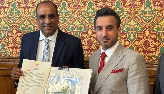 Lord Shaffaq Mohammed (left) presents an achievement award to British-Pakistani entrepreneur Shafiq Akbar at a ceremony at the House of Lords. &mdash;Reporter/Murtaza Ali Shah/File