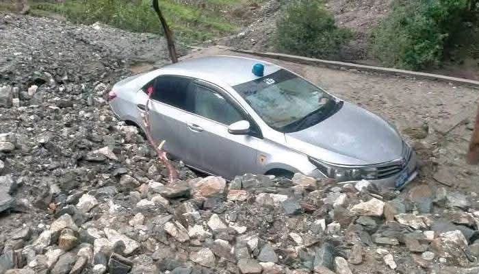 A car caught in a landslide on Babusar Chilas road. — Geo News