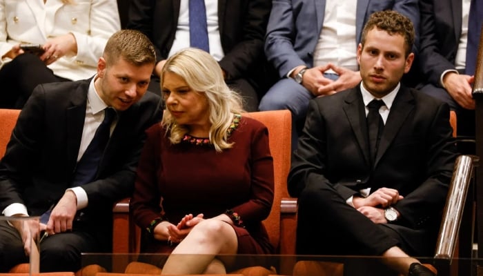 Sara Netanyahu, the wife of Israels Prime Minister Benjamin Netanyahu, sits with their sons Avner and Yair as the countrys new government is sworn in at the Knesset in Jerusalem, on 29 December 2022.  — AFP/