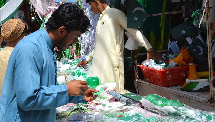 Man looking at a stall of decorative articles in Quetta on the eve of 75th Independence Day. Photo: INP
