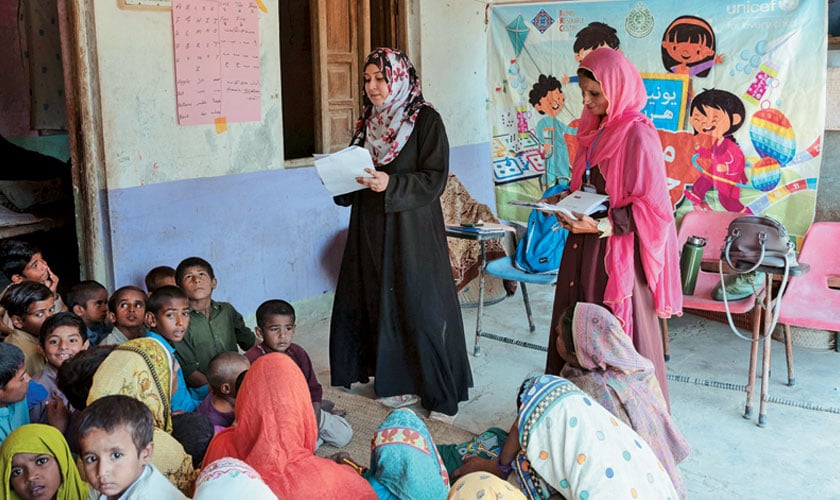 Zainab Ali, Psychologist Counselor for Mobile and Static Child Safe Spaces talks to women and children in a rural village in Khairpur district during a visit.