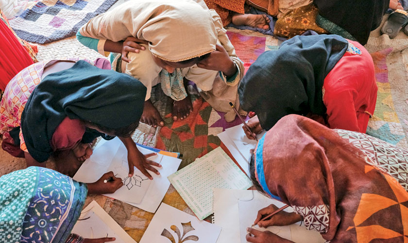 Girls make drawings during a visit from the Mobile and Static Child Safe Spaces in a small rural village in Khaipur district.
