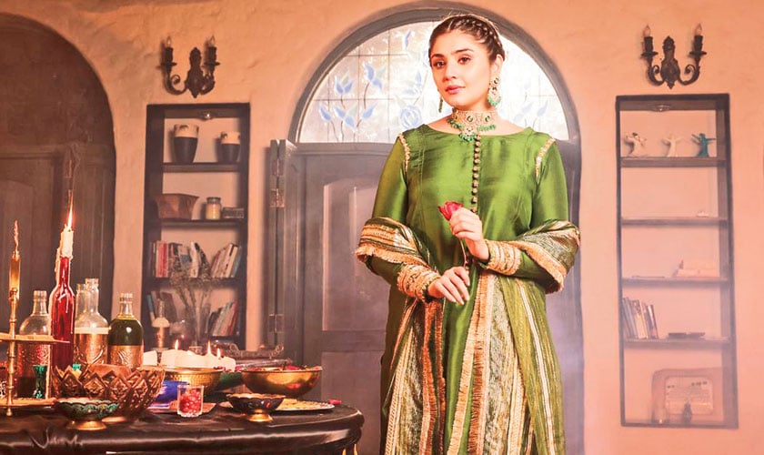 A raw silk shirt in olive green with delicately decorated buttons down the collar and boldly embellished sleeves. It’s worn with a raw silk shalwar with embroidered accents. It is accompanied with a gold and olive green organza dupatta with gota trims on all four sides.