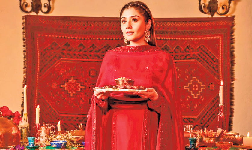 A plum-coloured pure raw silk shirt with an embellished collar and hand-embellished panels is paired with a statement organza dupatta. Matching straight trousers and fuss-free hair perfect the dreamy appearance for any event.