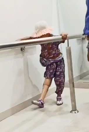 Mahzaib taking her first steps with the prosthetic leg