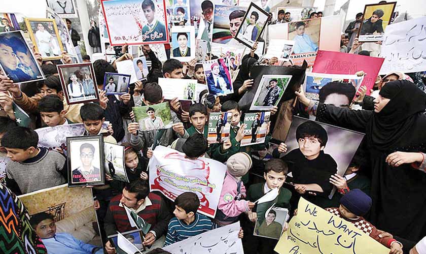 Family members hold photographs of students killed in the APS massacre.— Photo courtesy: APP.