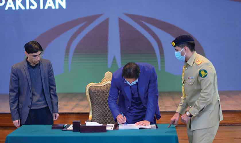 PM Imran Khan signs the public version of the national security policy. — Source: PM’s Office Twitter