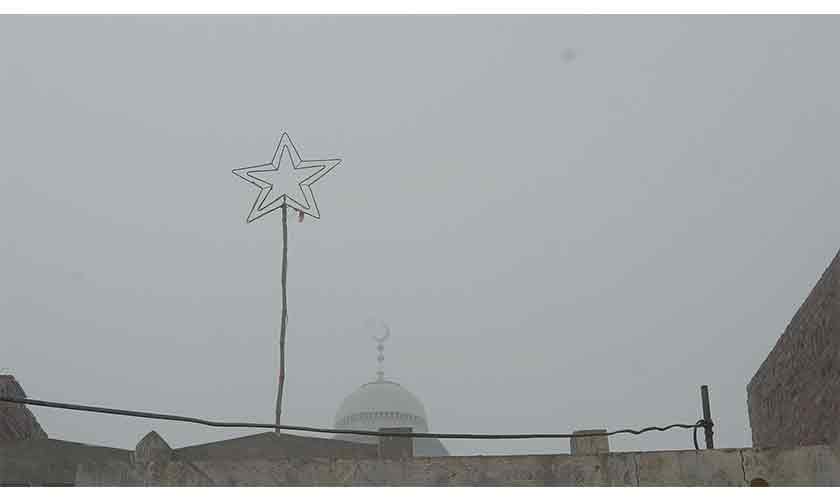 Festive lights: A Bethelehum Star decoration on the rooftop of a house and a crescent figure on top of a mosque in the background. — Photos by Abdullah Moin Afzal