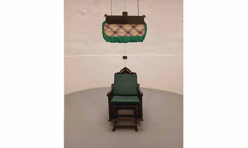 A rocking chair connected to a traditional fan with help of a pulley