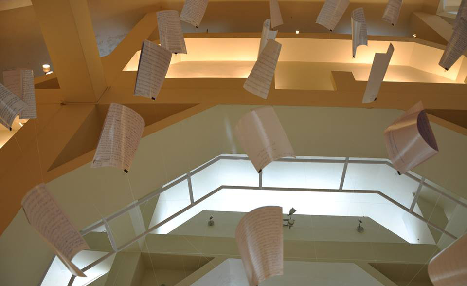 Essays by students hang at a readable distance from the ceiling.