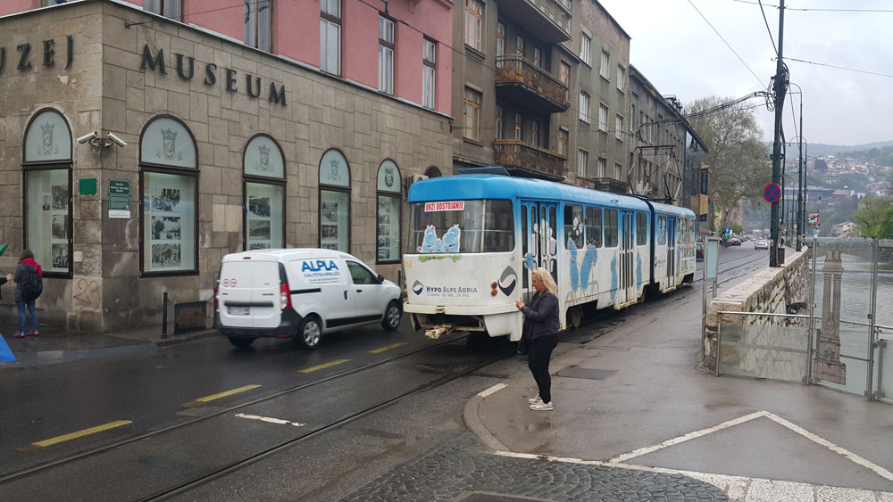 A woman stands on the exact spot where Austro-Hungarian heir apparent was assassinated triggering World War 1. The museum opposite documents the event