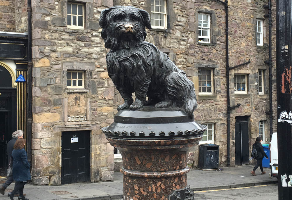 The statue of Greyfriars Bobby, a Skye terrier who, according to local lore, protected his master's grave for 14 years, stands outside the Greyfriars Kirk graveyard.