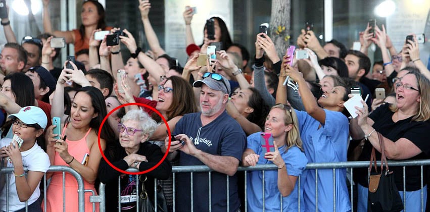 The photo that went viral: an old woman savours the moment while the crowd snaps pictures at a film premiere.