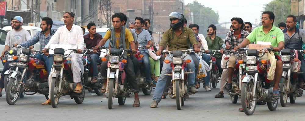 Traffic wardens across Lahore say that, out of every 15 motorcyclists they wave down for not wearing a helmet, they fine a maximum of two. -- Photos by Rahat Dar