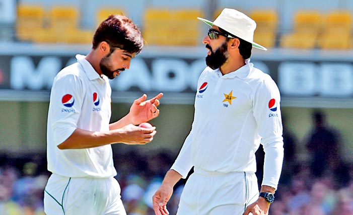 Brisbane: Pakistan captain Misbah ul-Haq (right) gives instructions to paceman  Mohammad Amir during the third day of their day-night Test against Australia here on Saturday. --AFP wirephoto