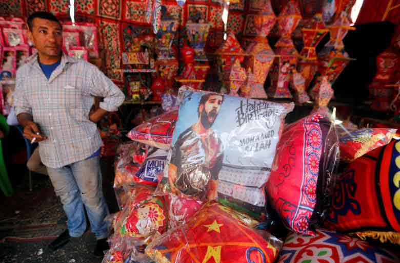 A seller waits for the customers near traditional Ramadan pillows and one depicting Liverpool's Egyptian forward soccer player Mohamed Salah, before the beginning of the holy fasting month of Ramadan in Cairo, Egypt. REUTERS
