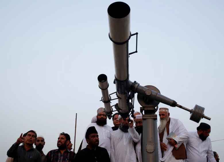 Members of the moon sighting committee gather and use telescope for the new moon that will mark the start of Ramadan, from Pakistan's Meteorological Department (PMD) building in Karachi, Pakistan. REUTERS