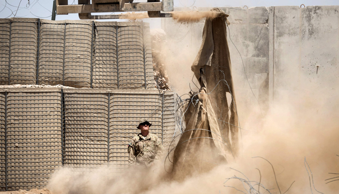 In this file photo taken on June 2, 2014 shows a US soldier watching as a lift is used to demolish Hesco barriers ahead of the withdrawl from Forward Operating Base Pasab in Kandahar province. — AFP