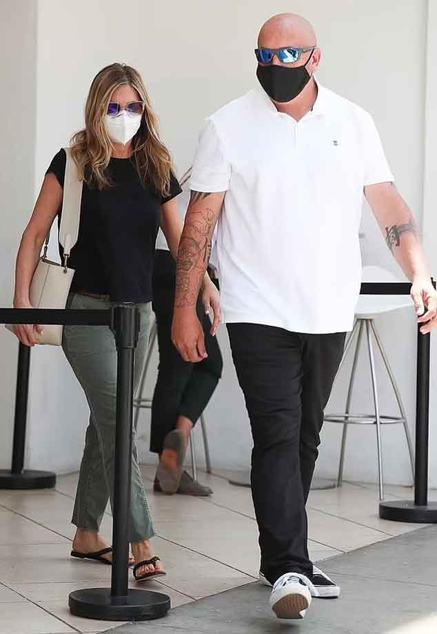 steps black she and T-shirt as pants looks green out Jennifer amazing Aniston in