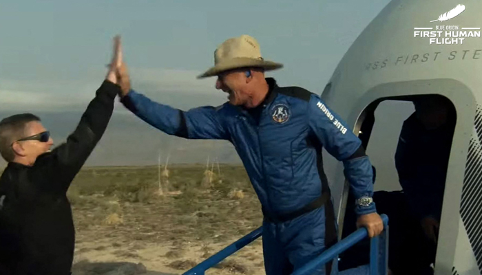 This still image taken from video by Blue Origin shows Jeff Bezos (R) celebrating after exiting Blue Origin´s reusable New Shepard craft capsule returned from space, safely landing on July 20, 2021. — AFP