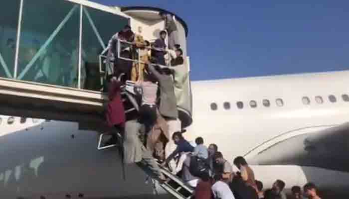 Desperate Afghans rushing to enter a plane at Kabul airport.