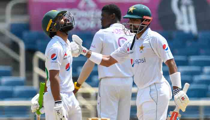 Fawad Alam (L) and Babar Azam (R) of Pakistan 100 partnership during day 1 of the 2nd Test between West Indies and Pakistan at Sabina Park, Kingston, Jamaica, on August 20, 2021.-AFP