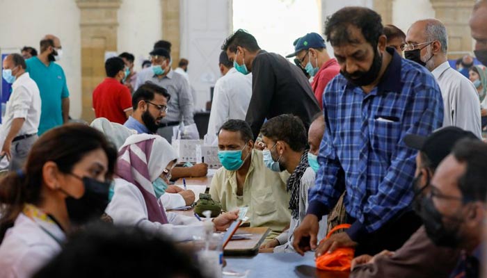 Orang-orang berkumpul untuk menerima dosis vaksin penyakit virus corona (COVID-19), di pusat vaksinasi di Karachi, Pakistan, 28 April 2021. — REUTERS