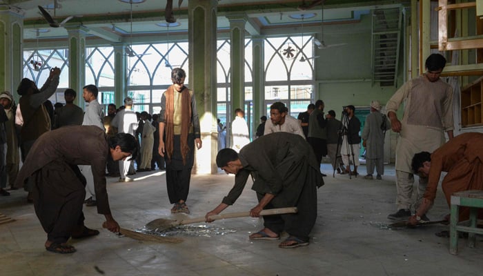 Afghan men remove broken glass inside a Shia mosque in Kandahar on October 15, 2021, after a suicide bomb attack during Friday prayers that killed at least 33 people and injured 74 others, Taliban officials said. — AFP/File