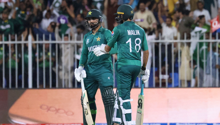 Pakistan´s Asif Ali and Shoaib Malik (R) talk during the ICC Twenty20 World Cup cricket match between Pakistan and New Zealand at the Sharjah Cricket Stadium in Sharjah on October 26, 2021. — AFP